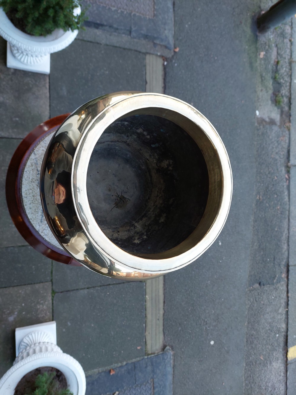 A polished Victorian brass planter featuring a rounded urn-shaped body resting on a stepped pedestal foot. View VI