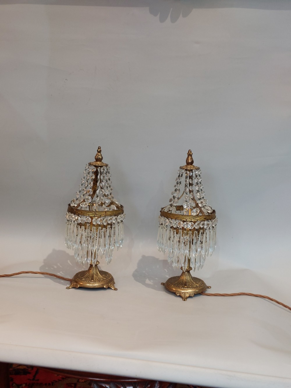 A pair of early 20th-century French style gilt brass table lustres featuring tiered strands of crystal beads and cascading prism drops. View II