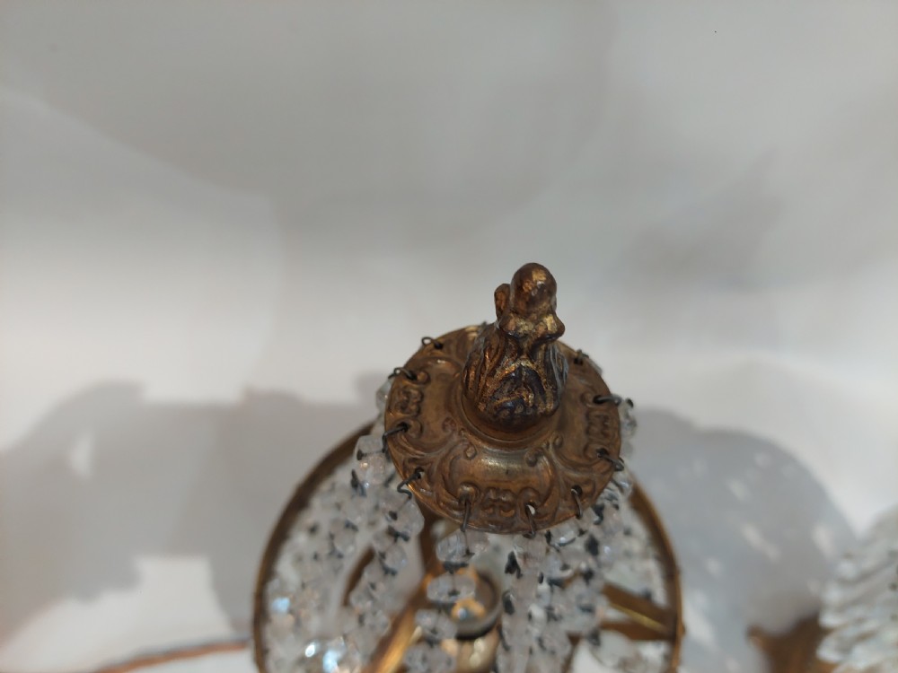 A pair of early 20th-century French style gilt brass table lustres featuring tiered strands of crystal beads and cascading prism drops. View V