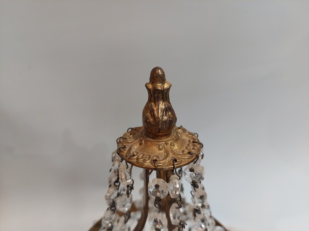 A pair of early 20th-century French style gilt brass table lustres featuring tiered strands of crystal beads and cascading prism drops. View VI