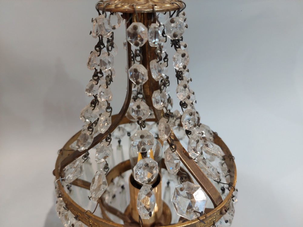 A pair of early 20th-century French style gilt brass table lustres featuring tiered strands of crystal beads and cascading prism drops. View VII