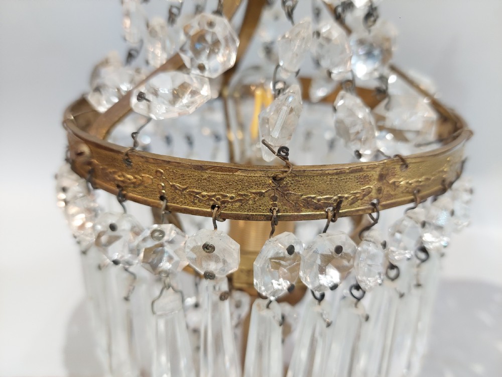 A pair of early 20th-century French style gilt brass table lustres featuring tiered strands of crystal beads and cascading prism drops. View IX