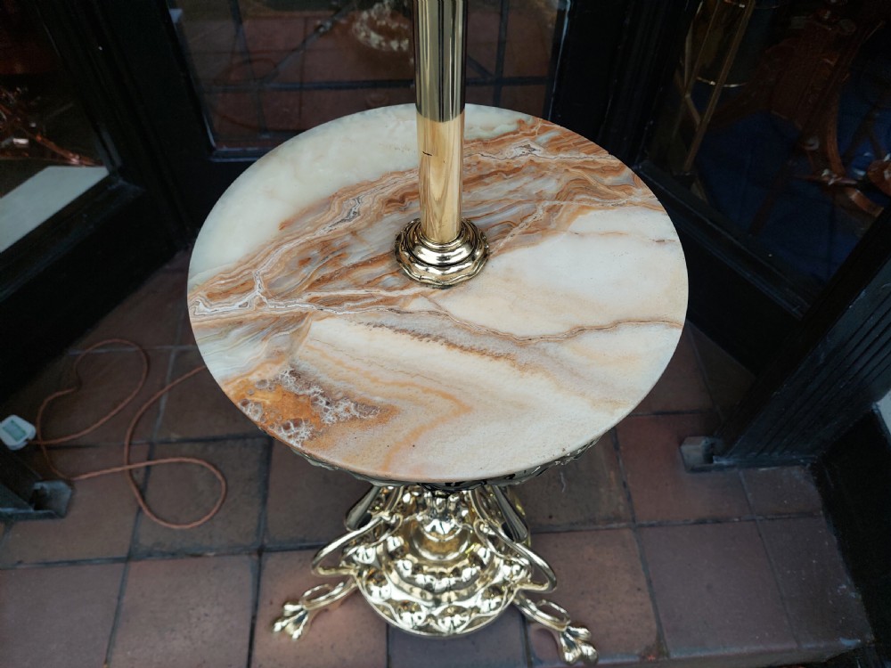 A late Victorian Art Nouveau brass standard lamp featuring an integrated marble tray, ornate curved legs, and a cream fringed lampshade. View II