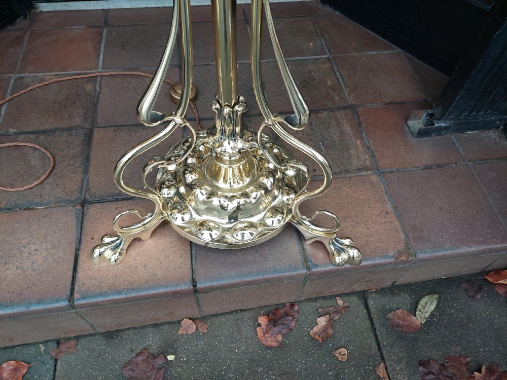 A late Victorian Art Nouveau brass standard lamp featuring an integrated marble tray, ornate curved legs, and a cream fringed lampshade. View III
