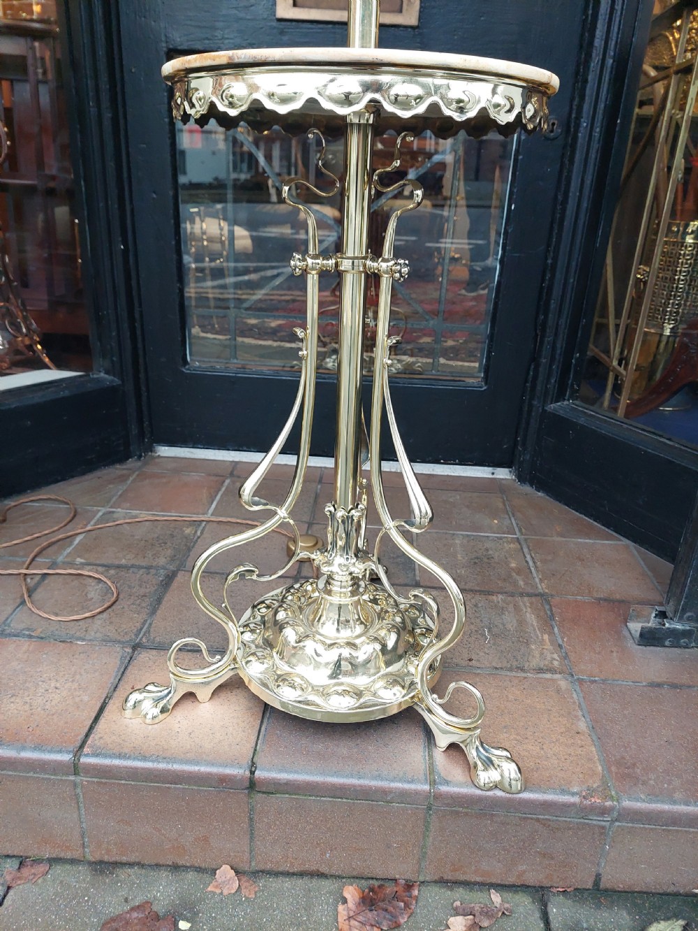 A late Victorian Art Nouveau brass standard lamp featuring an integrated marble tray, ornate curved legs, and a cream fringed lampshade. View IV
