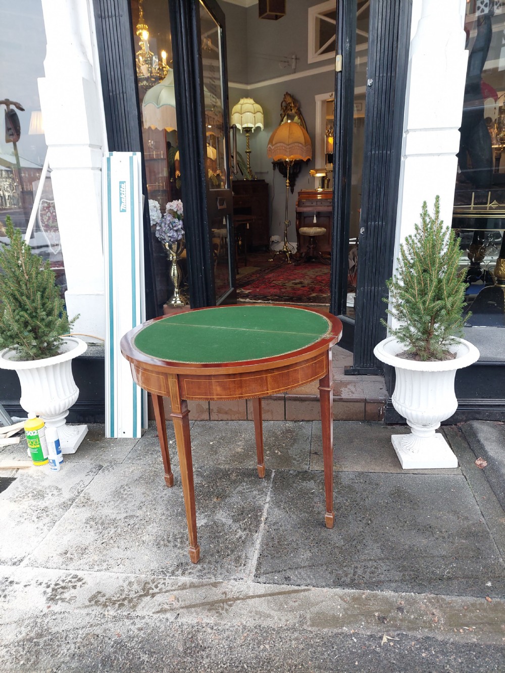 An Edwardian demilune card table crafted from mahogany with fine boxwood stringing and square tapered legs. View VII