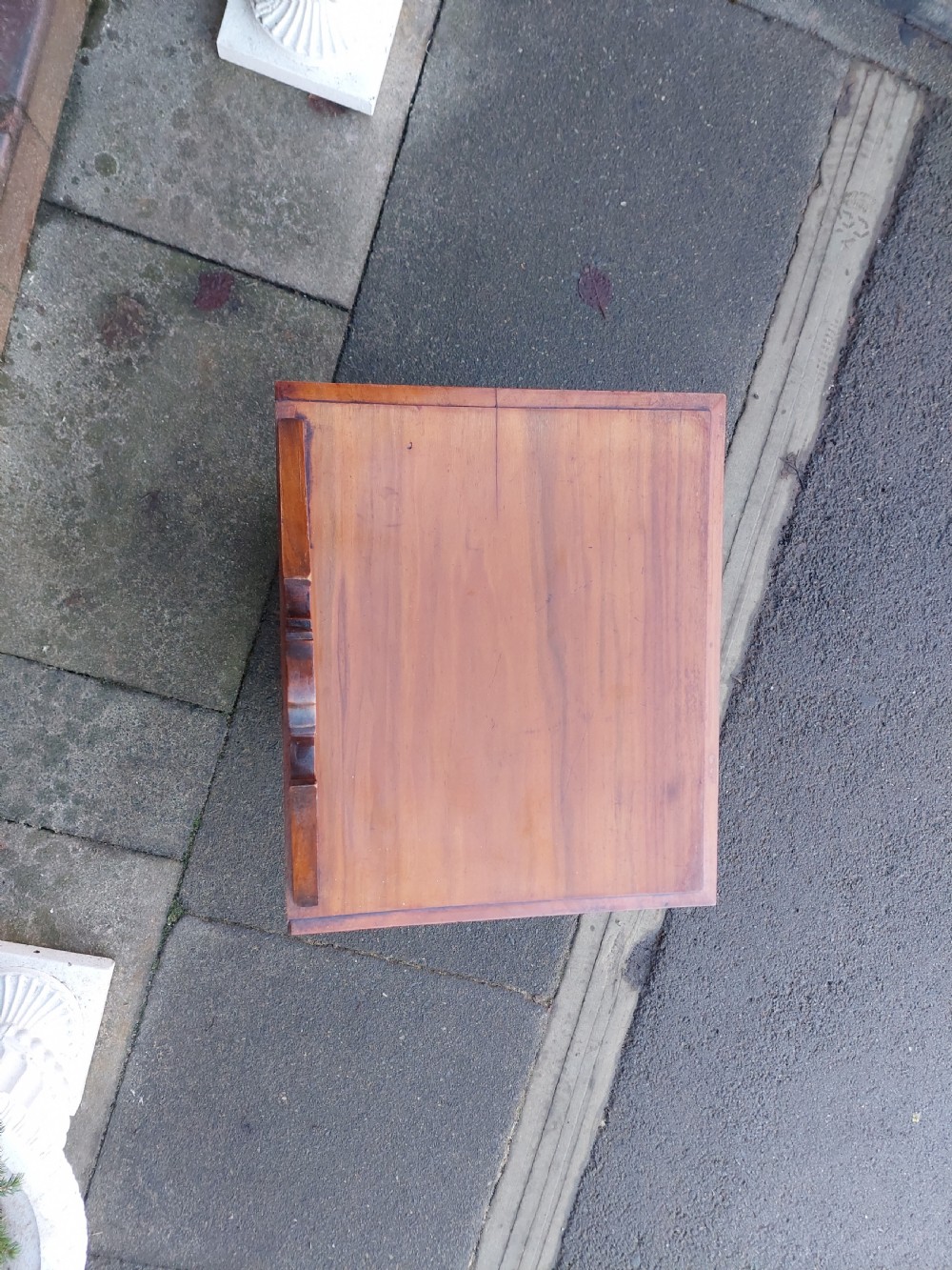 An Edwardian walnut bedside cabinet featuring a single cupboard door with a figured wood panel, a carved top gallery, and a solid plinth base. View III