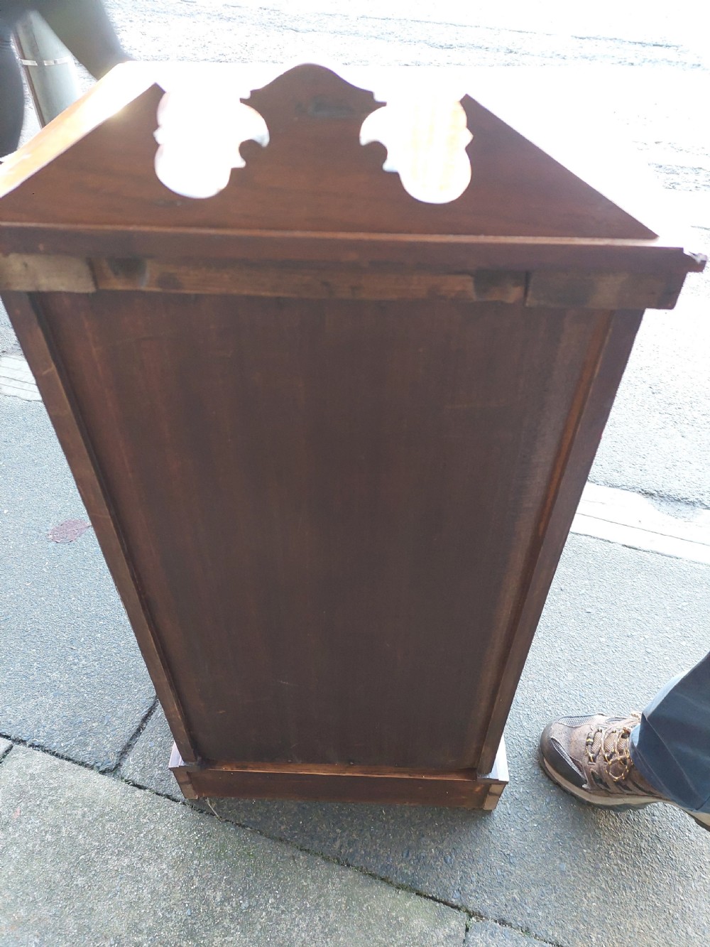 An Edwardian walnut bedside cabinet featuring a single cupboard door with a figured wood panel, a carved top gallery, and a solid plinth base. View VI
