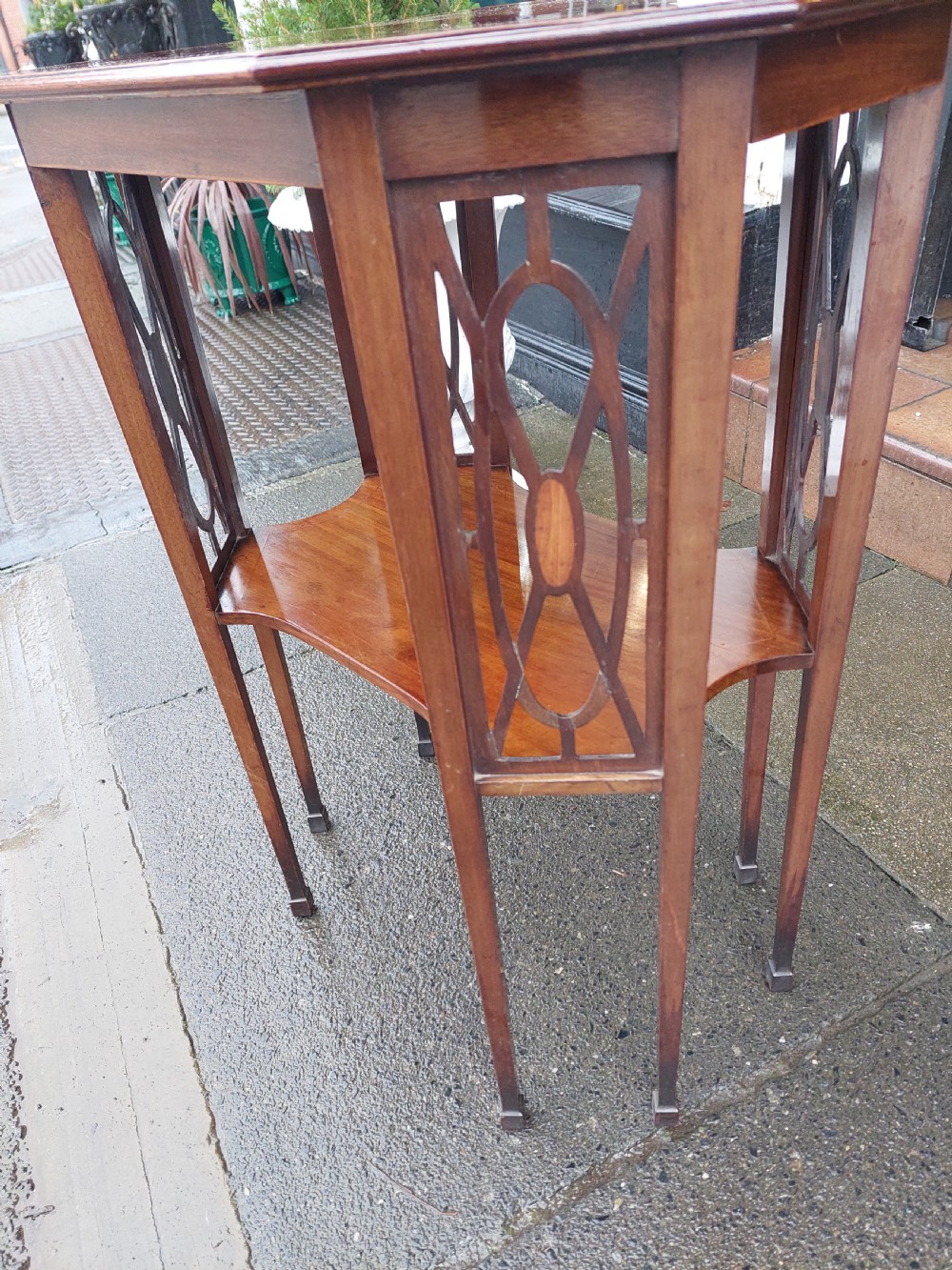 An Edwardian octagonal mahogany occasional table featuring inlaid satinwood borders, pierced side fretwork panels, and a lower tier supported by tapered square legs. View IV