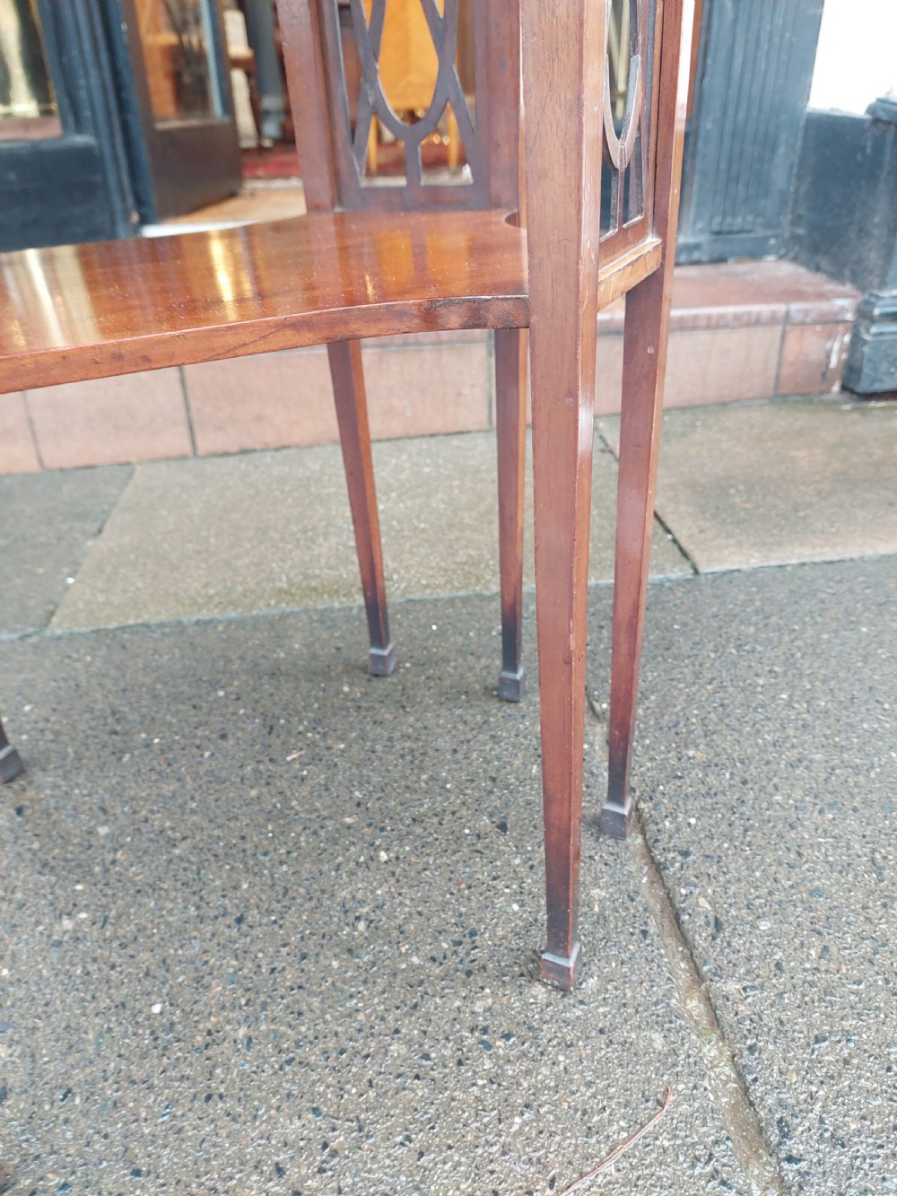 An Edwardian octagonal mahogany occasional table featuring inlaid satinwood borders, pierced side fretwork panels, and a lower tier supported by tapered square legs. View VI