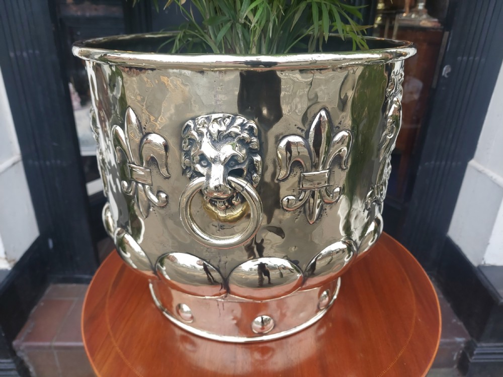 A round Victorian metal log bucket featuring embossed heraldic crests, lion mask ring handles, and gadrooned relief work. View III