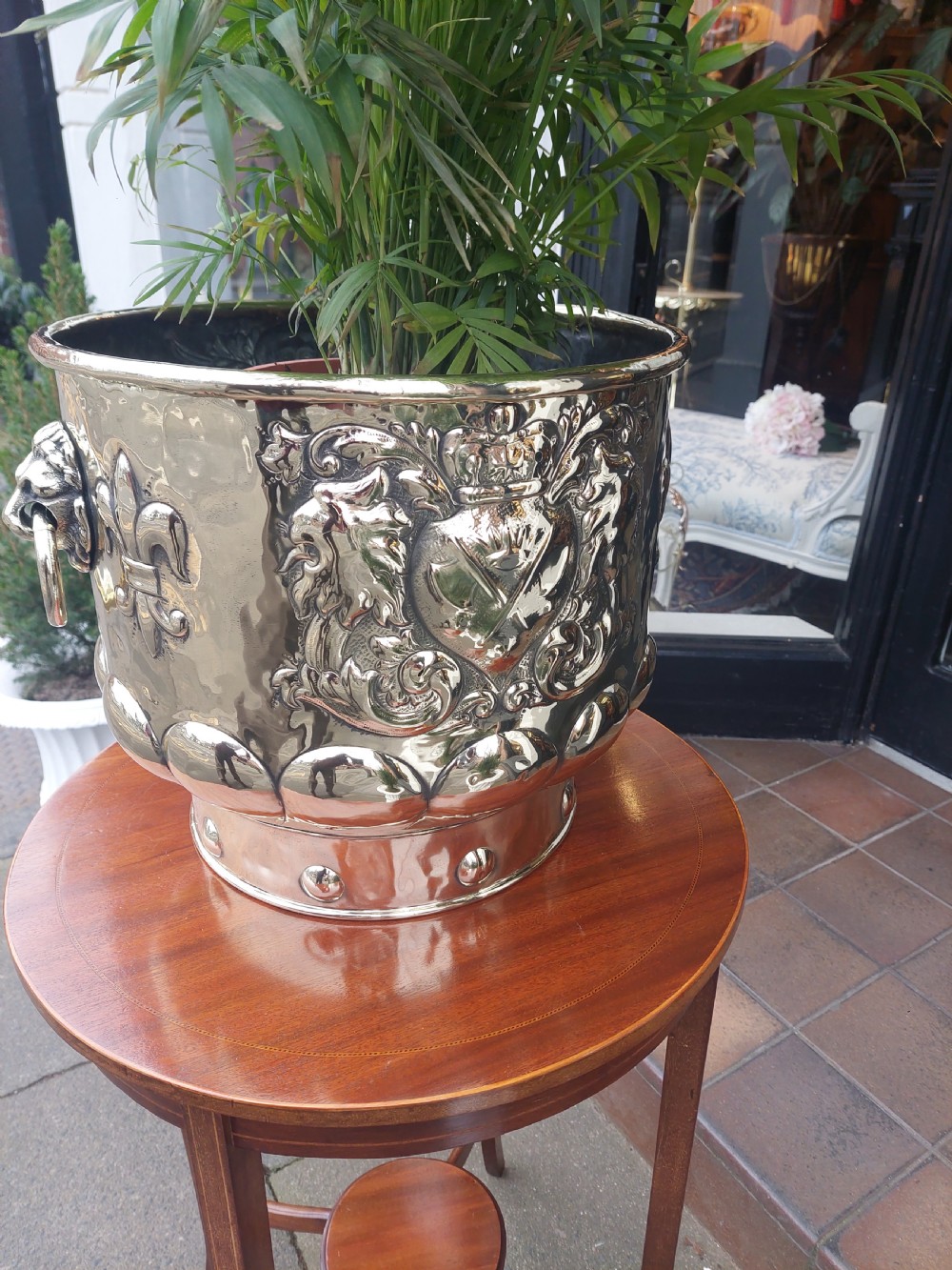A round Victorian metal log bucket featuring embossed heraldic crests, lion mask ring handles, and gadrooned relief work. View IX