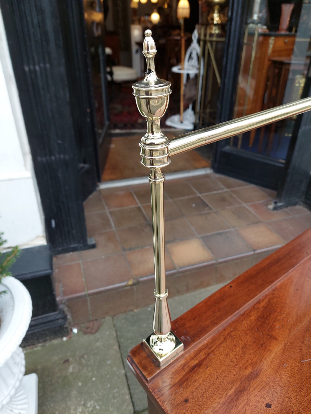 A Georgian mahogany hall table with a rounded bowfront top, a single central drawer with brass handle, a brass finial gallery rail, and four square tapered legs. View VIII