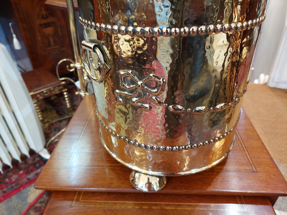 A cylindrical Victorian brass coal receiver featuring embossed garland motifs, beaded horizontal bands, side ring handles, and a fitted domed lid with a finial. View III