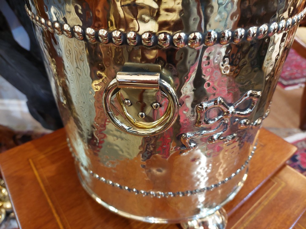 A cylindrical Victorian brass coal receiver featuring embossed garland motifs, beaded horizontal bands, side ring handles, and a fitted domed lid with a finial. View IV