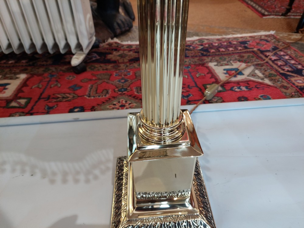 A brass column table lamp featuring a reeded stem, stepped square base, and a cream fabric dome shade trimmed with dark braid and clear glass droplet fringe. View III