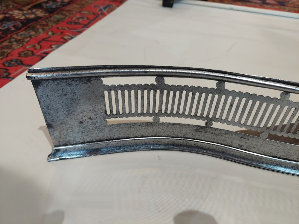A Georgian serpentine polished steel fire fender featuring pierced fretwork detail along the front curve. View III