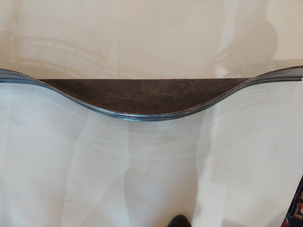 A Georgian serpentine polished steel fire fender featuring pierced fretwork detail along the front curve. View V