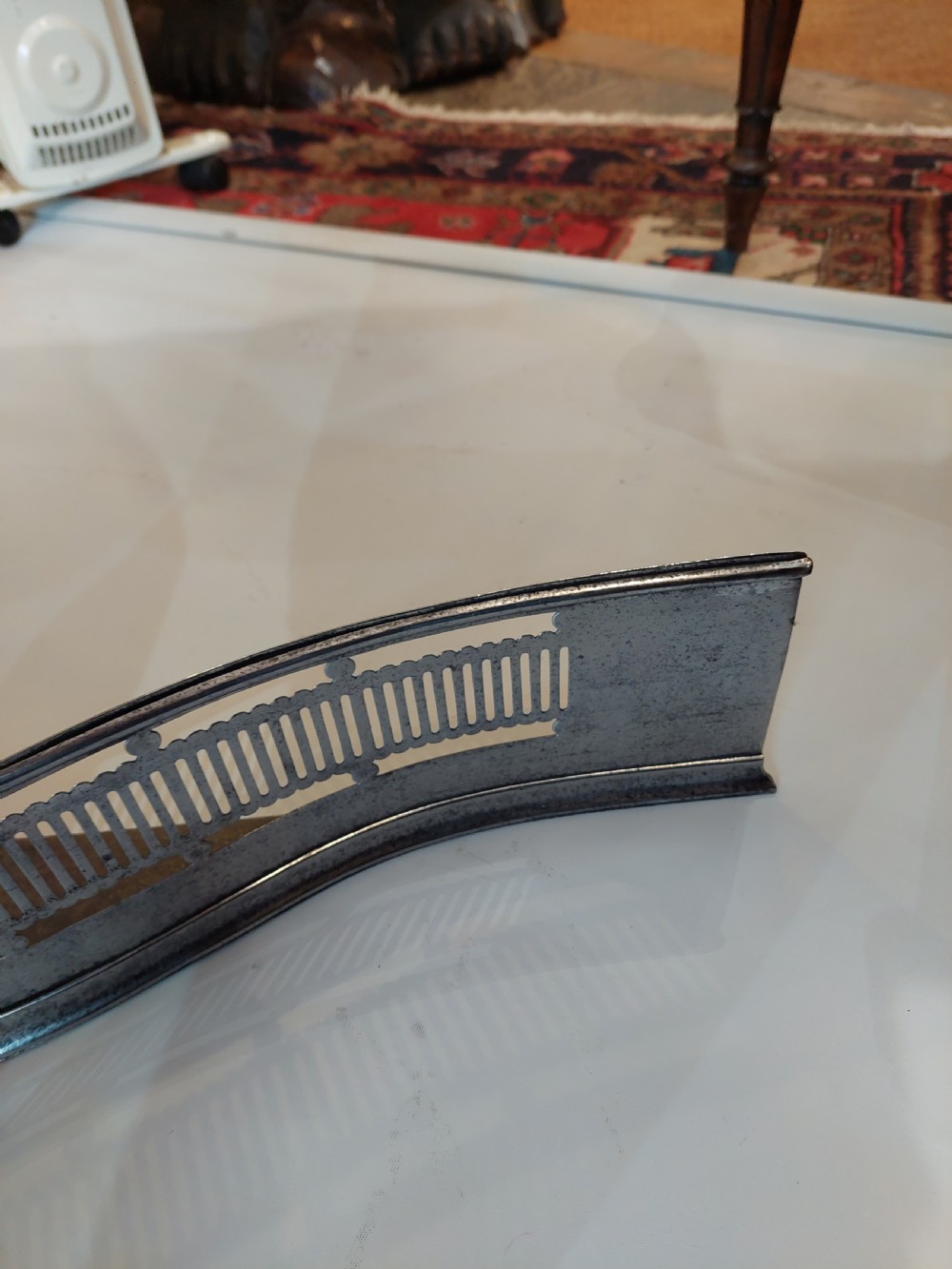 A Georgian serpentine polished steel fire fender featuring pierced fretwork detail along the front curve. View VI