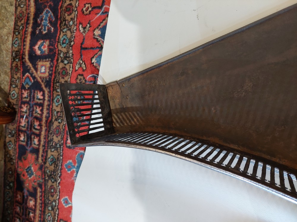 A polished steel Georgian fireplace fender featuring a serpentine front profile and vertical pierced slat fretwork. View IV