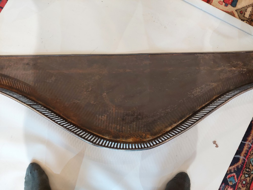 A polished steel Georgian fireplace fender featuring a serpentine front profile and vertical pierced slat fretwork. View V