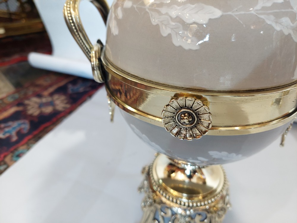 A pair of late 19th-century gilt brass and grey porcelain table lamps featuring fringed fabric lampshades. View VIII