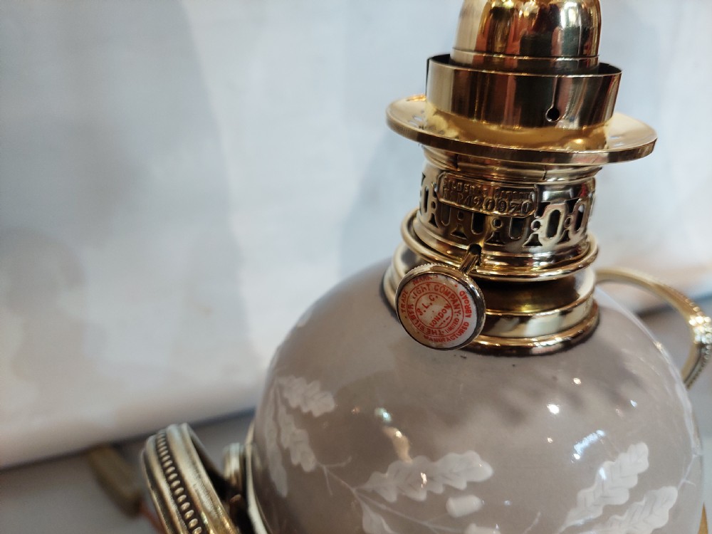 A pair of late 19th-century gilt brass and grey porcelain table lamps featuring fringed fabric lampshades. View IX