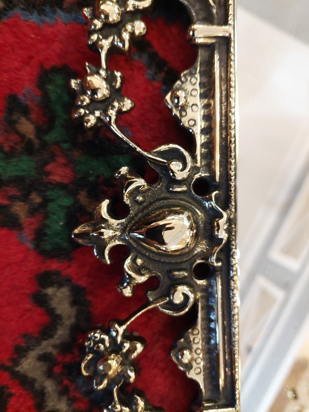 An ornate late Victorian rectangular wall mirror featuring a heavily detailed cast brass frame decorated with scrolls, floral motifs, and a crest detail at the top. View IV