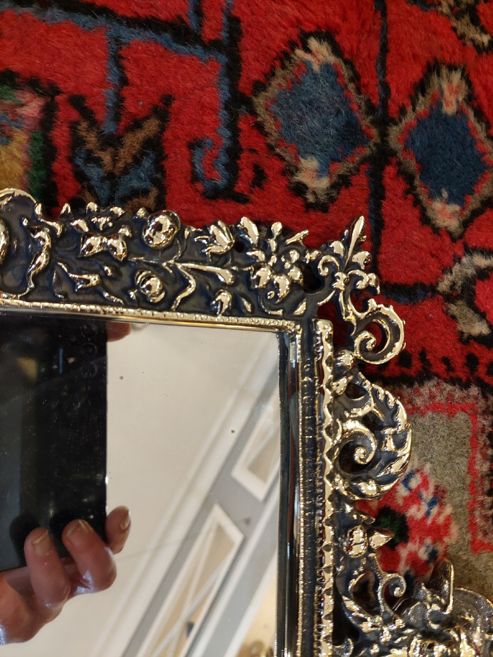 An ornate late Victorian rectangular wall mirror featuring a heavily detailed cast brass frame decorated with scrolls, floral motifs, and a crest detail at the top. View VI