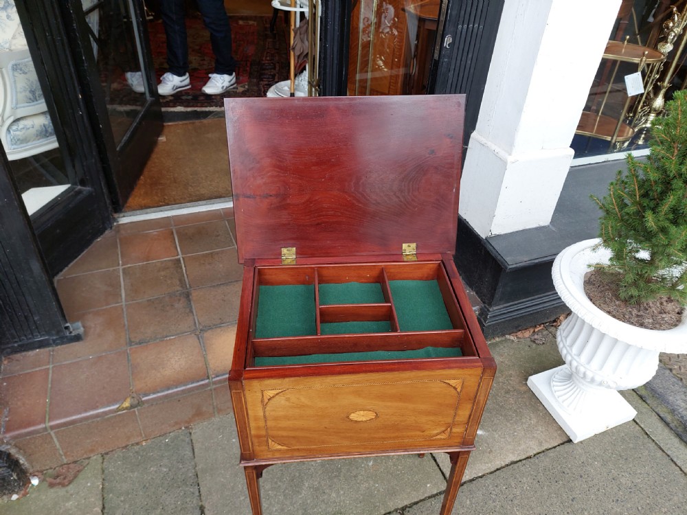 An Edwardian mahogany work table featuring satinwood line inlay and central shell marquetry motifs, elevated on slender splayed legs. View VII