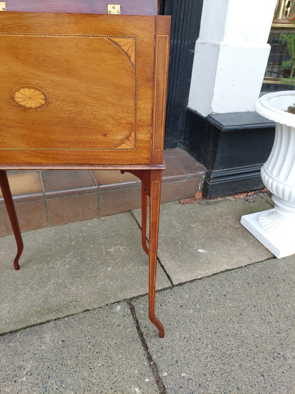 An Edwardian mahogany work table featuring satinwood line inlay and central shell marquetry motifs, elevated on slender splayed legs. View VIII