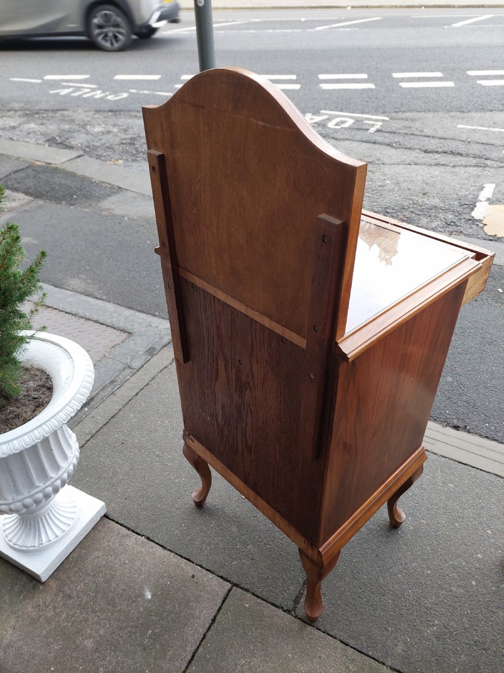 A matching pair of Art Deco figured walnut bedside cabinets with shaped upstands, single drawers, and lower cupboards on cabriole legs. View III