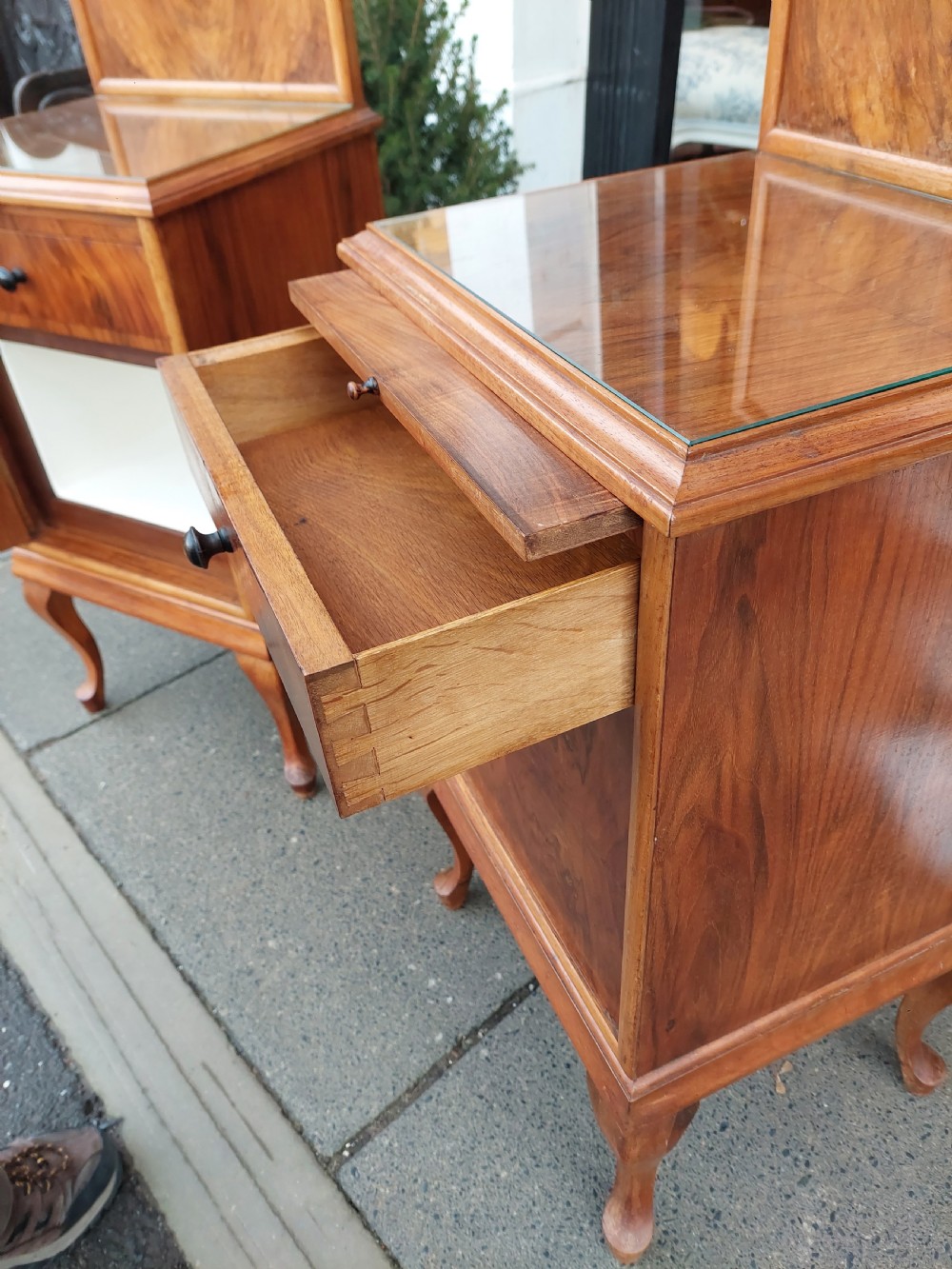 A matching pair of Art Deco figured walnut bedside cabinets with shaped upstands, single drawers, and lower cupboards on cabriole legs. View IV