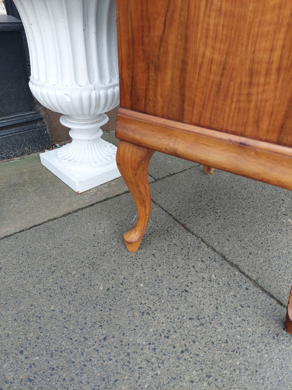 A matching pair of Art Deco figured walnut bedside cabinets with shaped upstands, single drawers, and lower cupboards on cabriole legs. View IX