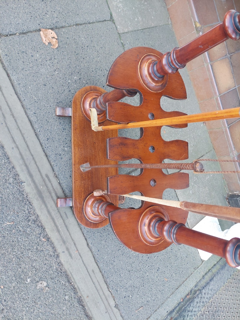 A Victorian turned mahogany whip stand featuring finial uprights, multiple upper pegs, a notched central shelf, and a solid base on feet. View III