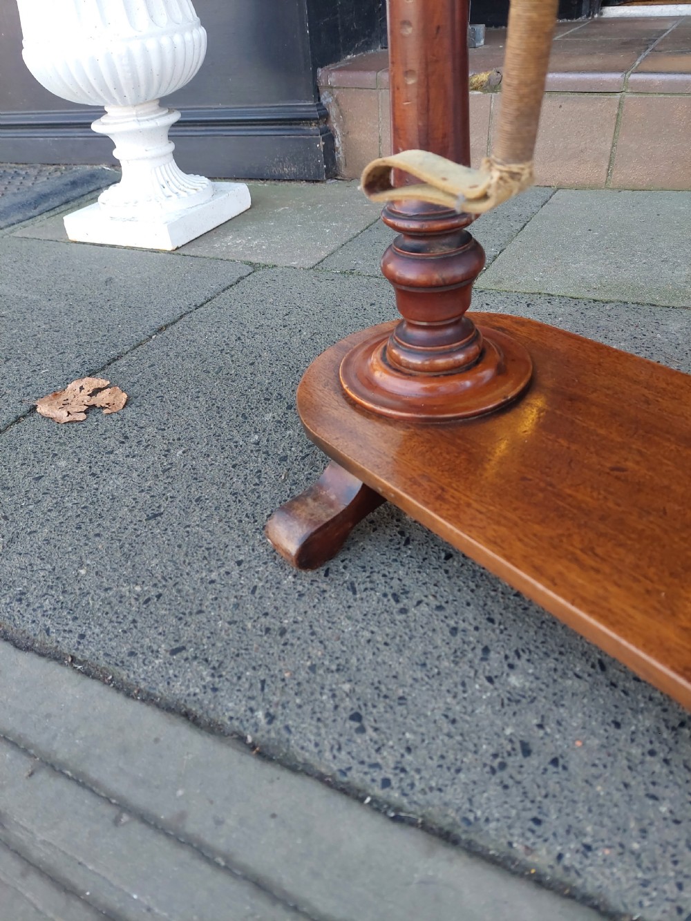 A Victorian turned mahogany whip stand featuring finial uprights, multiple upper pegs, a notched central shelf, and a solid base on feet. View VI