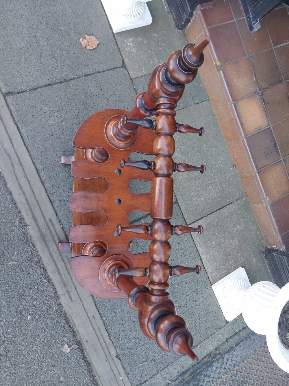 A Victorian turned mahogany whip stand featuring finial uprights, multiple upper pegs, a notched central shelf, and a solid base on feet. View VII