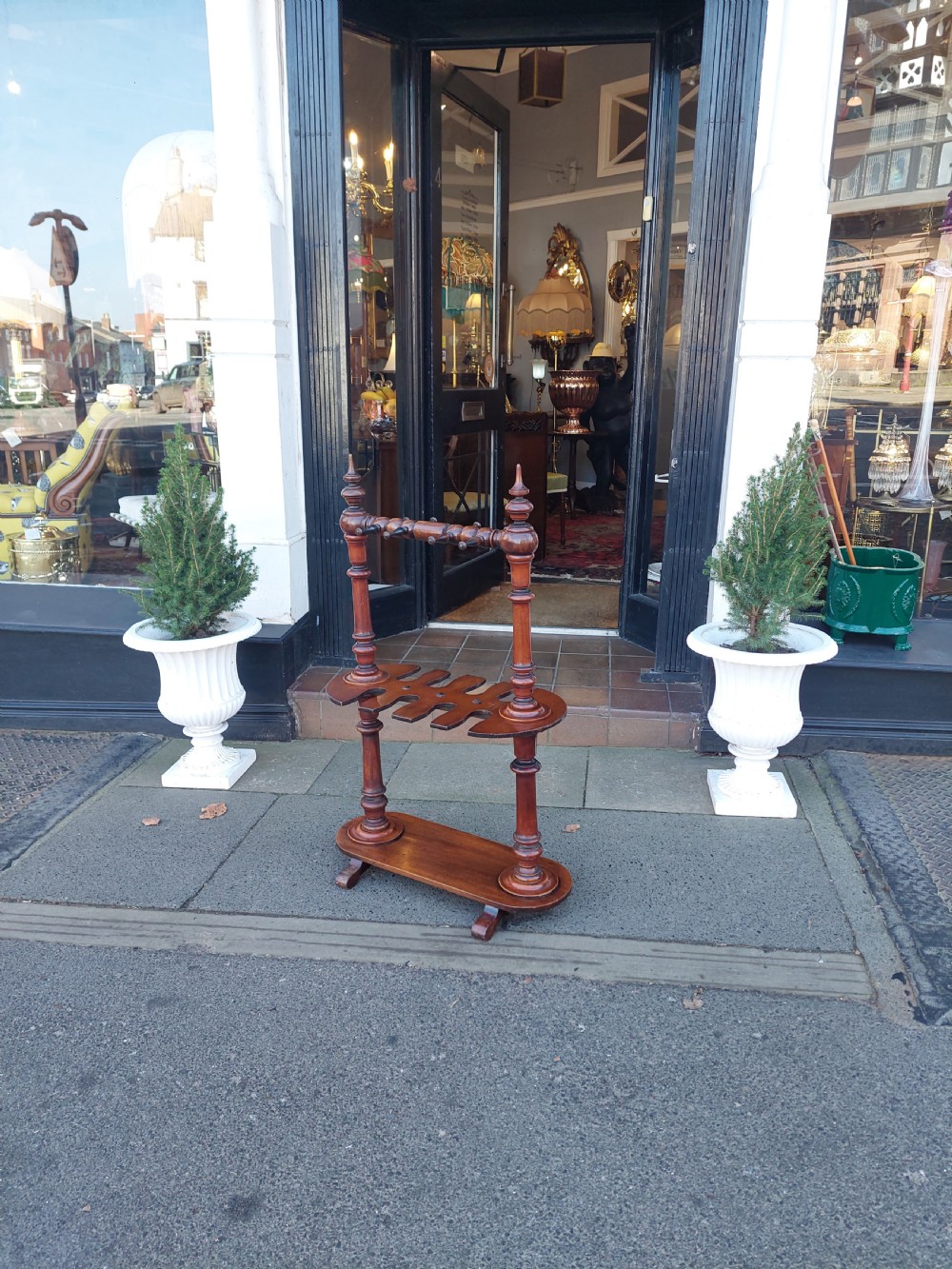 A Victorian turned mahogany whip stand featuring finial uprights, multiple upper pegs, a notched central shelf, and a solid base on feet. View VIII