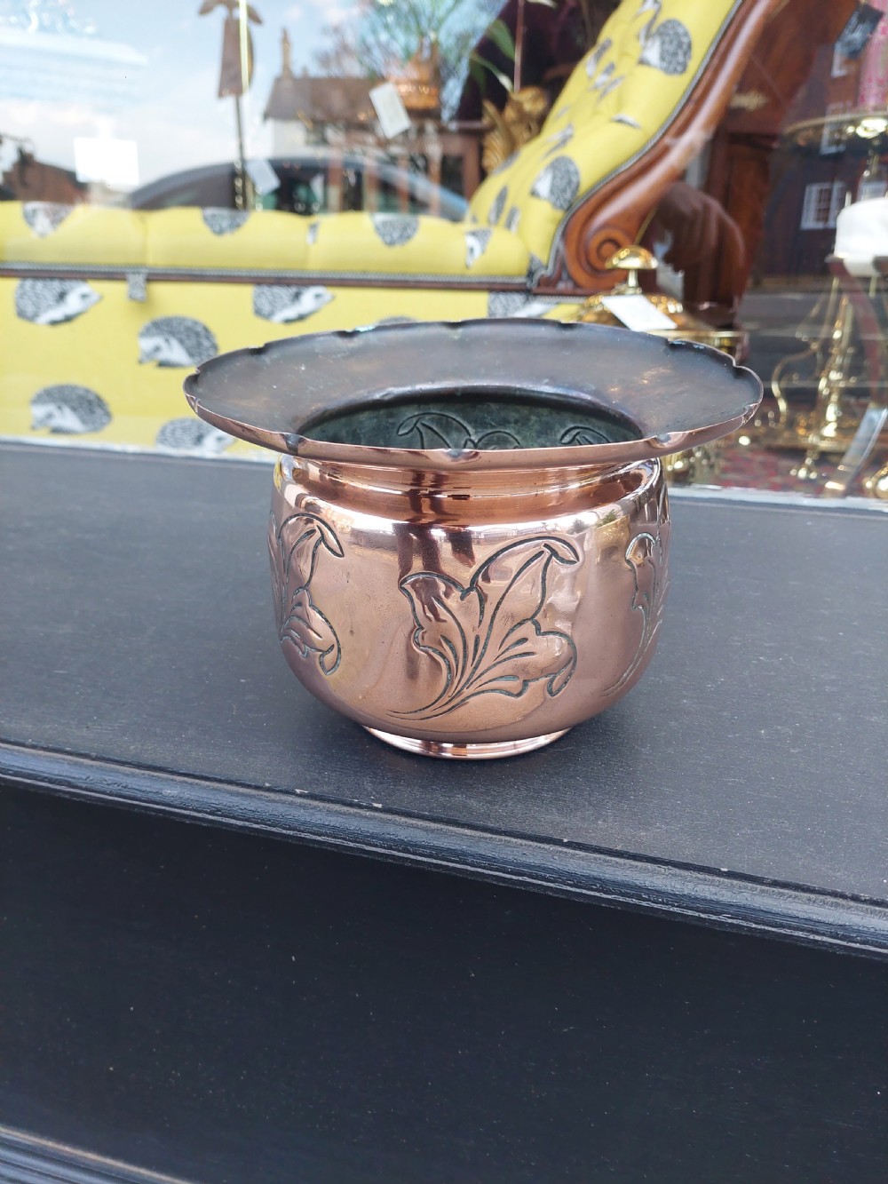 A late Victorian copper planter featuring embossed foliate designs around the rounded body and a flared rim. View II