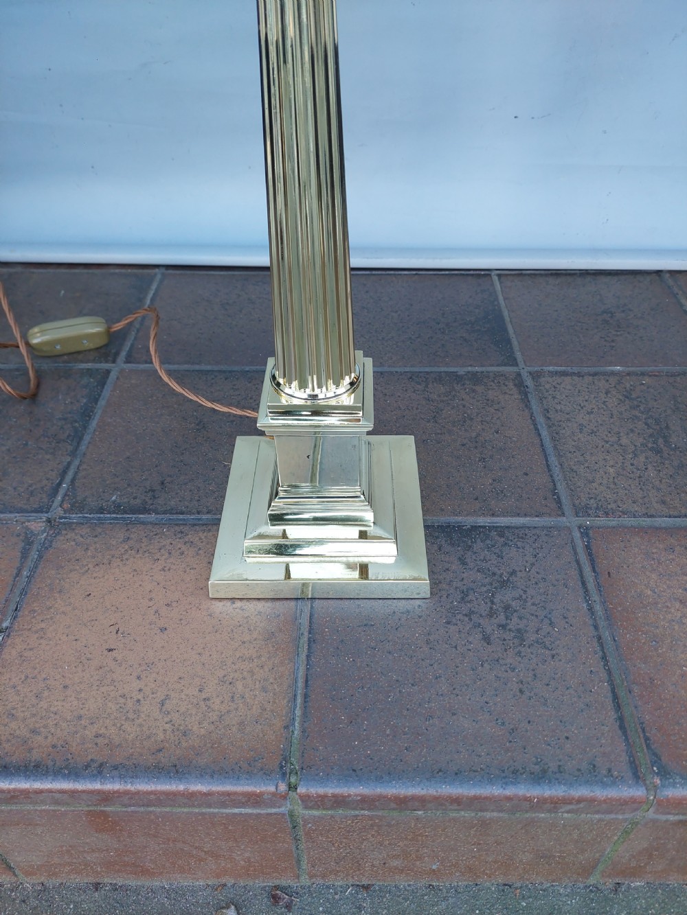 A late nineteenth-century Corinthian column oil lamp featuring a fluted stem, polished metal reservoir, and a white fabric dome shade trimmed with blue piping and long glass bead fringe. View VI