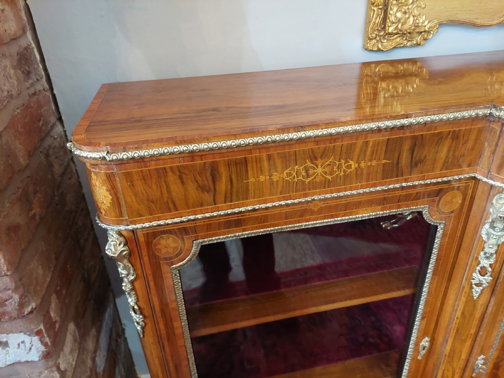 A nineteenth-century Victorian breakfront cabinet in burr walnut with marquetry inlay, gilt metal mounts, a central panelled door, and two side glazed display sections with velvet lining. View II