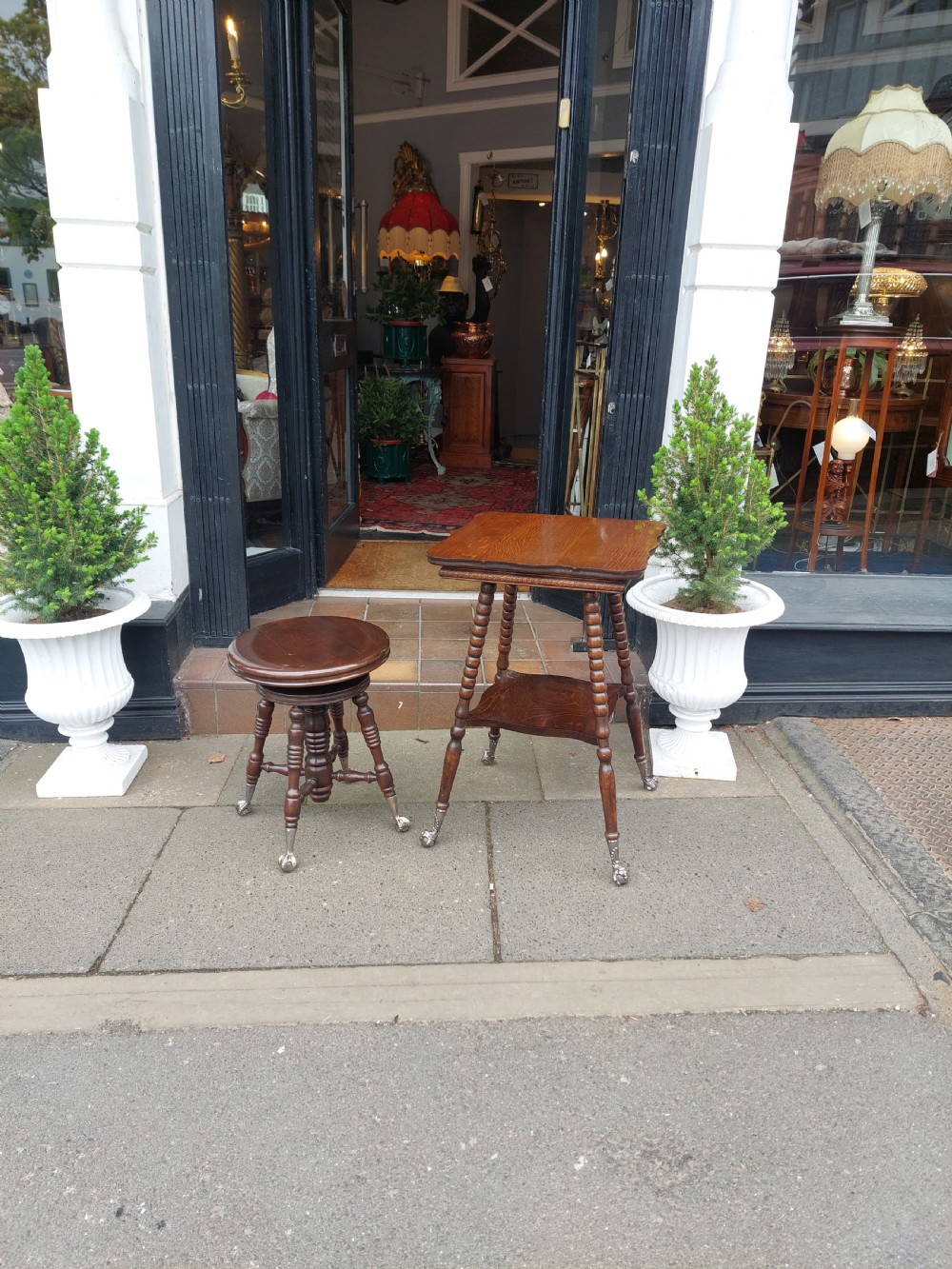 An early 20th-century dark mahogany piano stool featuring a circular swivel top, turned spindled legs, central pillar, and metal claw feet with glass balls. View VIII