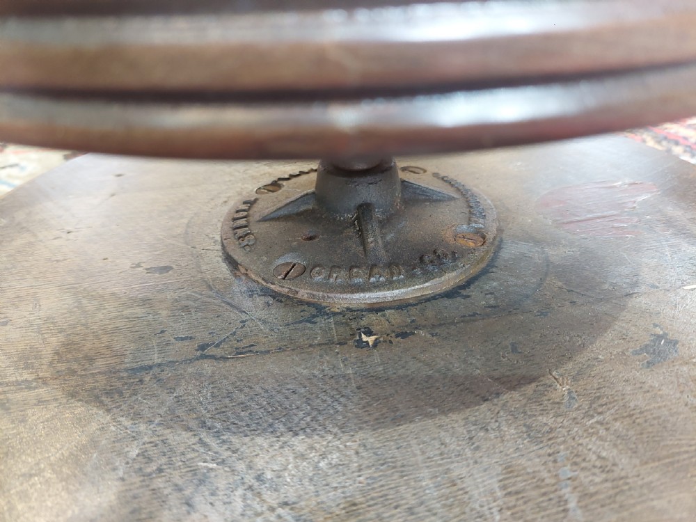 An early 20th-century dark mahogany piano stool featuring a circular swivel top, turned spindled legs, central pillar, and metal claw feet with glass balls. View IX