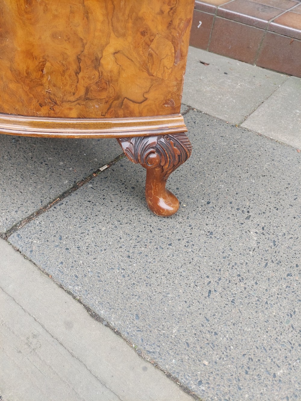 An early twentieth-century demi-lune drinks cabinet crafted from golden burr walnut veneer with carved cabriole legs and brass hardware. View III