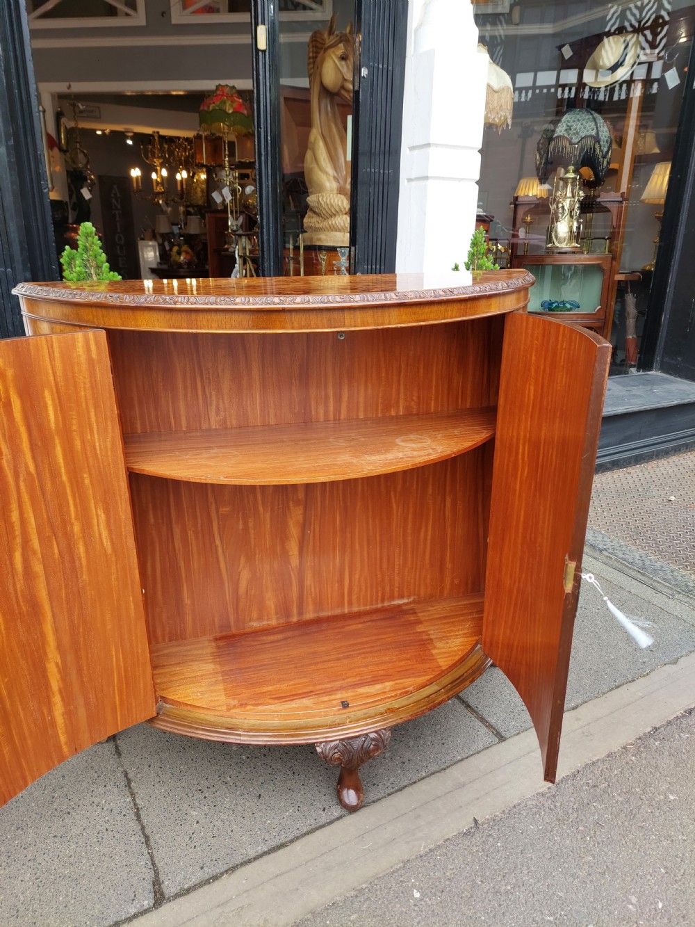 An early twentieth-century demi-lune drinks cabinet crafted from golden burr walnut veneer with carved cabriole legs and brass hardware. View XII