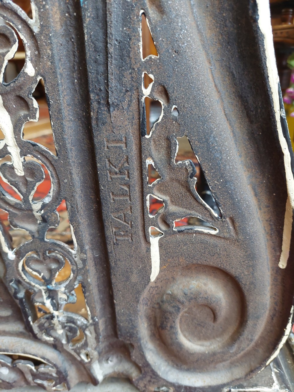 An ornate 19th-century black cast iron hall stand featuring coat hooks, intricate scrollwork, umbrella compartments, and a removable drip tray base. View X