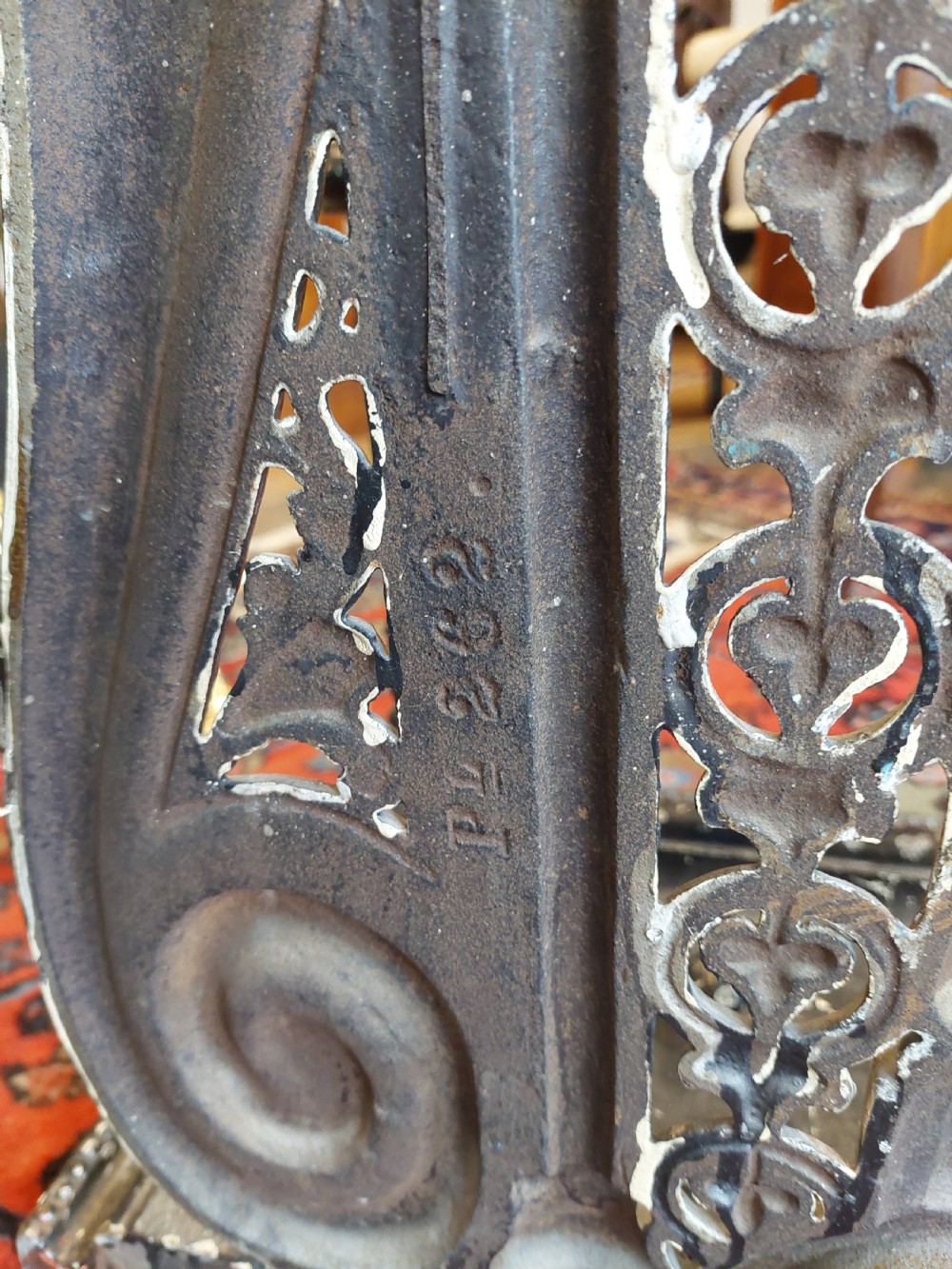 An ornate 19th-century black cast iron hall stand featuring coat hooks, intricate scrollwork, umbrella compartments, and a removable drip tray base. View XI