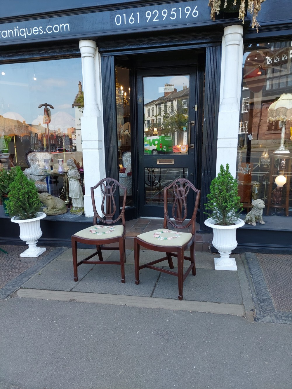 A set of six late nineteenth-century mahogany dining chairs featuring shield-shaped backs with carved lyre motifs and pale green upholstered seats. View II