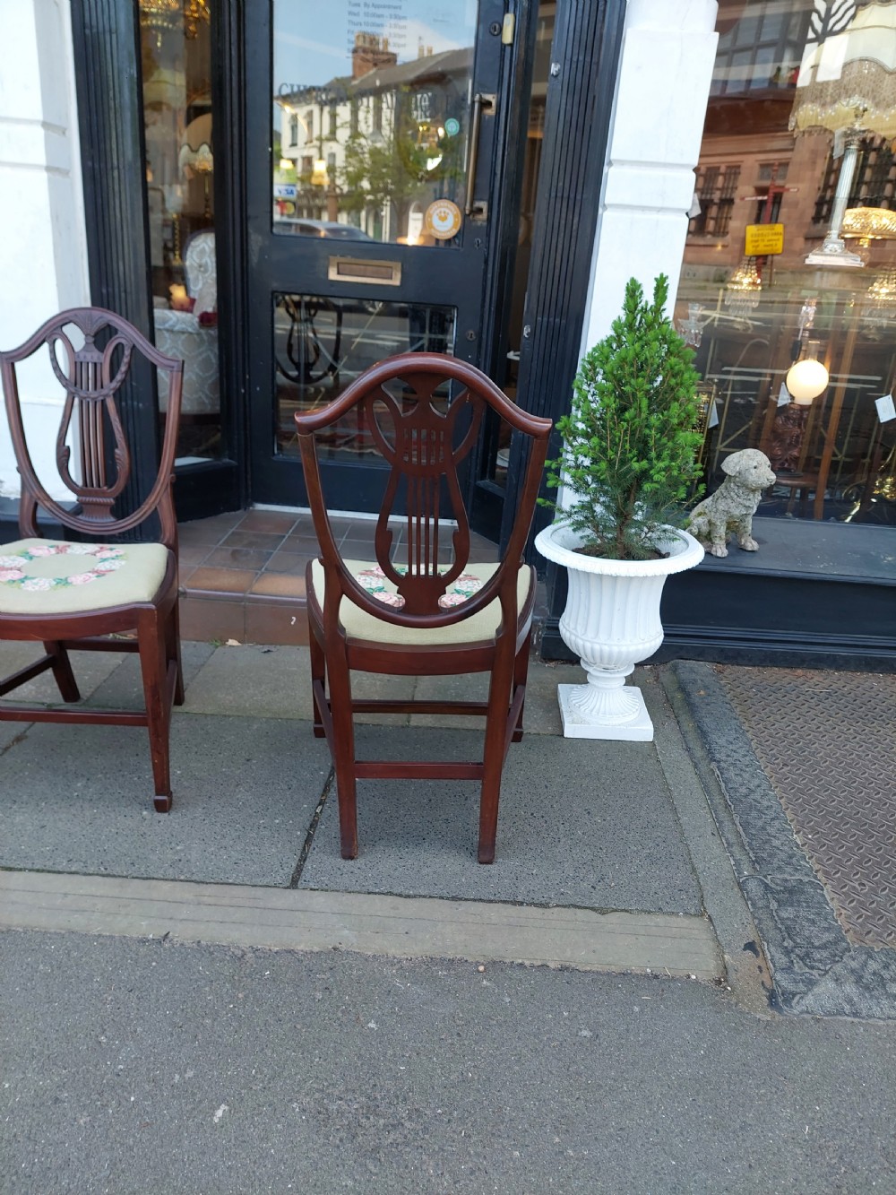 A set of six late nineteenth-century mahogany dining chairs featuring shield-shaped backs with carved lyre motifs and pale green upholstered seats. View X