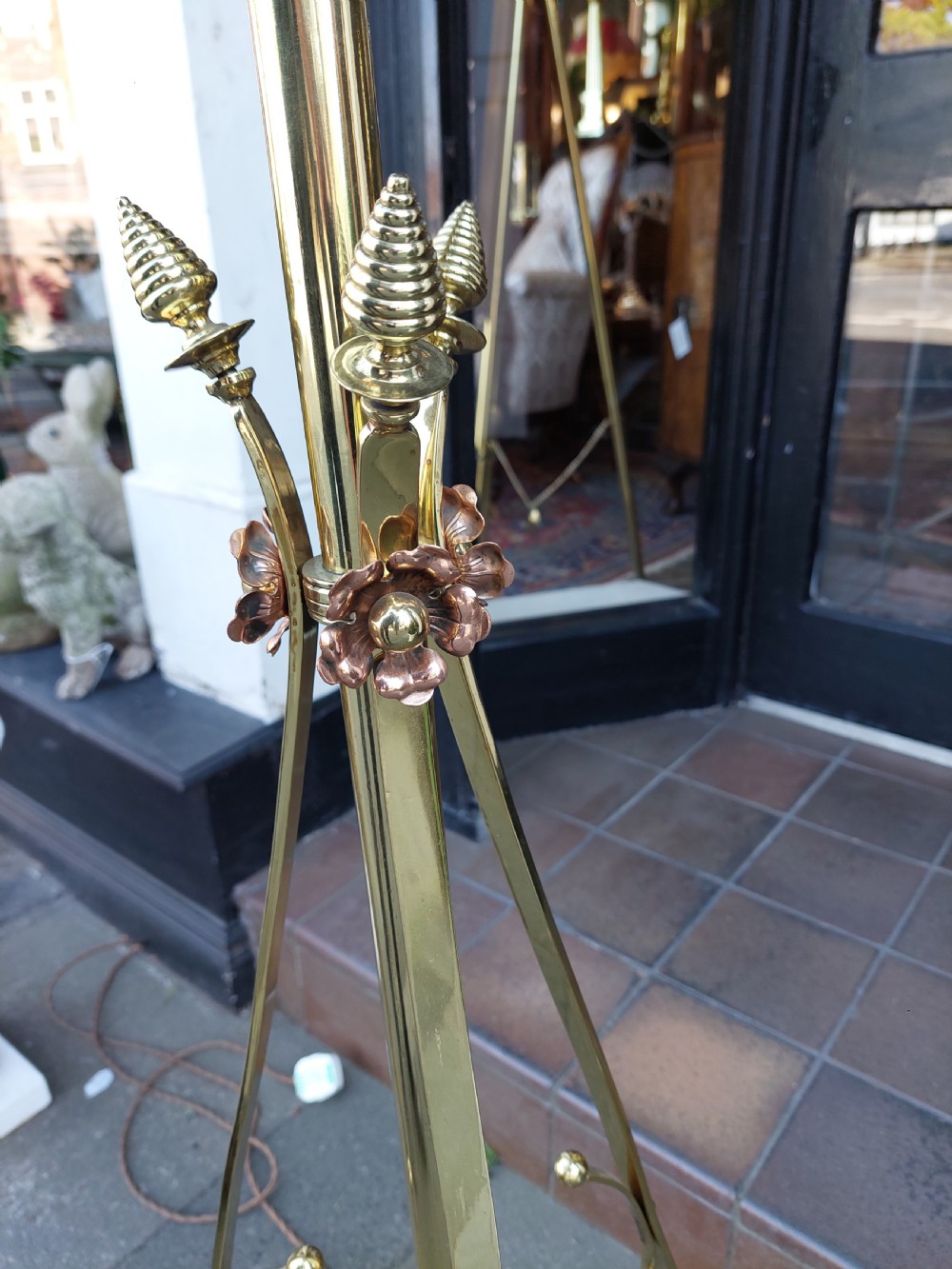 An Arts and Crafts brass standard floor lamp featuring a scrollwork tripod base, floral copper accents, and a fringe-trimmed domed shade. View III